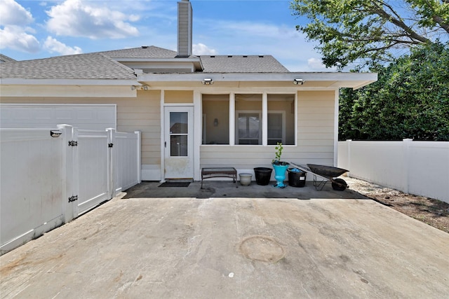 10027 Hanover Dr, Providence Village, TX 76227 - back of property with an attached garage, a shingled roof, and a patio