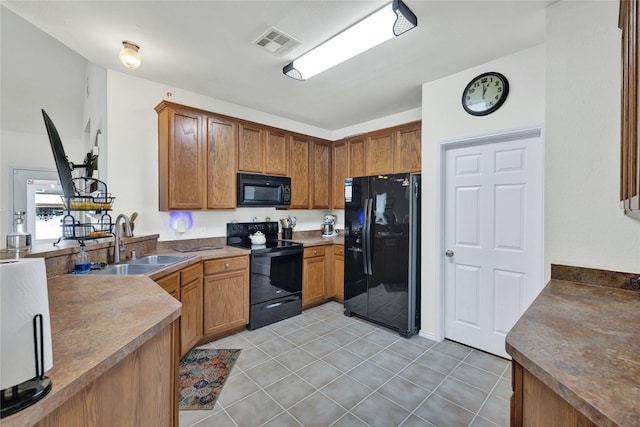 10027 Hanover Dr, Providence Village, TX 76227 - kitchen with black appliances, brown cabinetry, light tile patterned flooring, and a peninsula