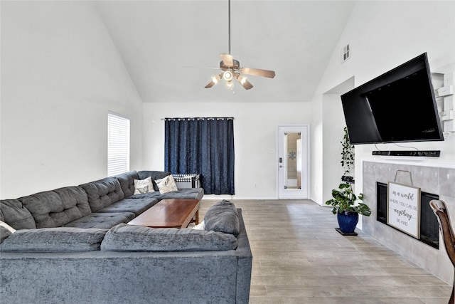 10027 Hanover Dr, Providence Village, TX 76227 - living area with high vaulted ceiling, a fireplace, a ceiling fan, and light wood-style floors