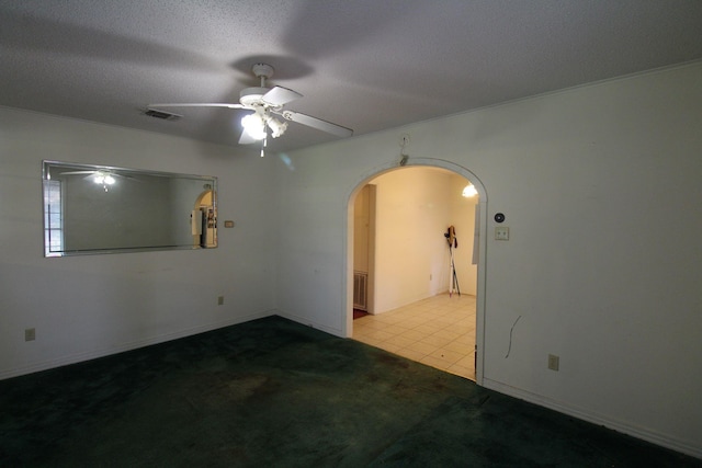 1 Mason St, Minden, LA 71055 - tiled spare room featuring arched walkways, ceiling fan, carpet floors, and a textured ceiling