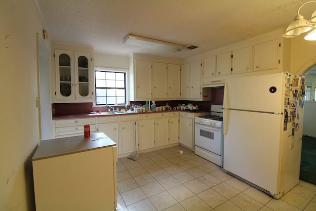 1 Mason St, Minden, LA 71055 - kitchen with white appliances, a textured ceiling, light tile patterned floors, glass insert cabinets, and under cabinet range hood