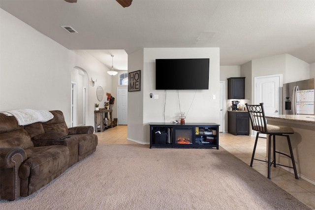 628 Cameron Way, Azle, TX 76020 - living area featuring light tile patterned floors, ceiling fan, arched walkways, and light carpet