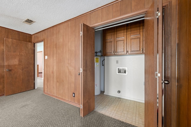 7655 Veal Station Rd, Azle, TX 76020 - laundry room featuring electric water heater, hookup for a washing machine, cabinet space, a textured ceiling, and wood walls