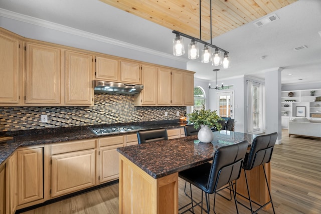 8347 Mountainview Dr, Dallas, TX 75249 - kitchen with light brown cabinets, stainless steel gas stovetop, under cabinet range hood, crown molding, and open floor plan