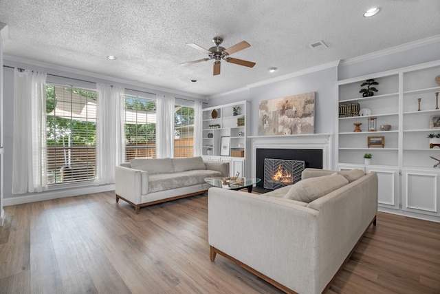 8347 Mountainview Dr, Dallas, TX 75249 - living room with a textured ceiling, ornamental molding, a lit fireplace, a ceiling fan, and wood finished floors