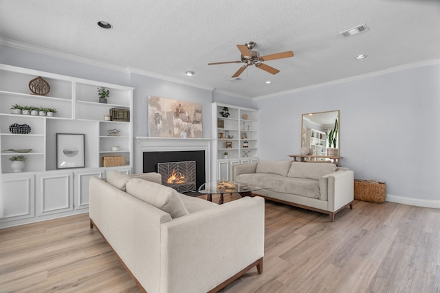 8347 Mountainview Dr, Dallas, TX 75249 - living area with ceiling fan, light wood-style floors, a fireplace, ornamental molding, and a textured ceiling