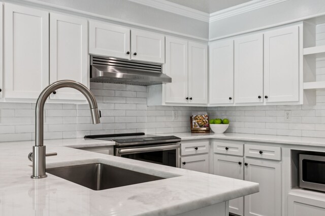 6714 Barkworth Dr, Dallas, TX 75248 - kitchen featuring under cabinet range hood, open shelves, stainless steel microwave, ornamental molding, and white cabinetry