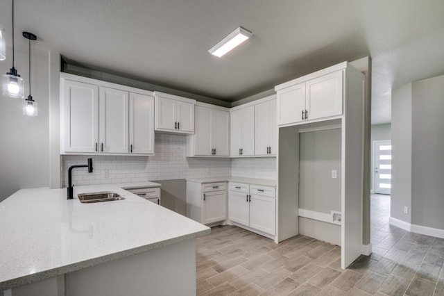 2517 Meaders Ave, Fort Worth, TX 76112 - kitchen featuring decorative backsplash, light stone countertops, white cabinets, pendant lighting, and light wood-type flooring