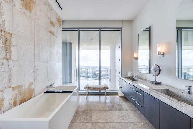 1717 Arts Plz Unit 1808, Dallas, TX 75201 - bathroom featuring double vanity, a freestanding bath, and healthy amount of natural light