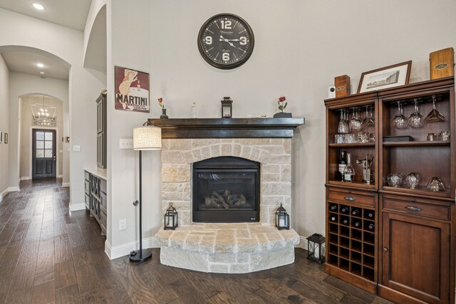 12229 Prudence Dr, Fort Worth, TX 76052 - living room featuring dark wood-style floors, a fireplace, a chandelier, recessed lighting, and arched walkways