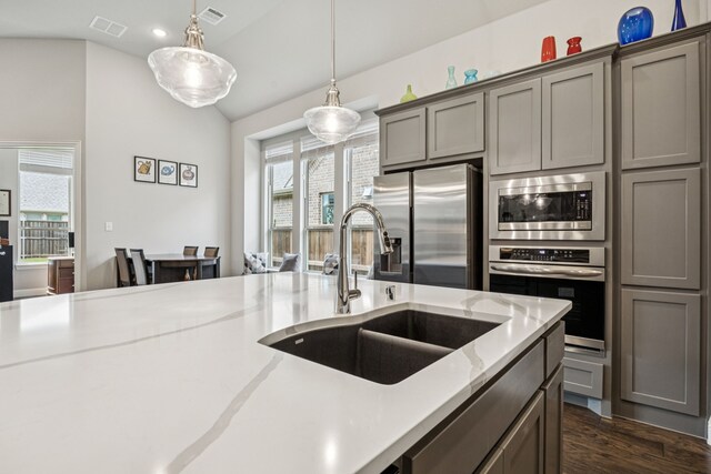 12229 Prudence Dr, Fort Worth, TX 76052 - kitchen featuring stainless steel appliances, gray cabinetry, hanging light fixtures, dark wood-style flooring, and vaulted ceiling