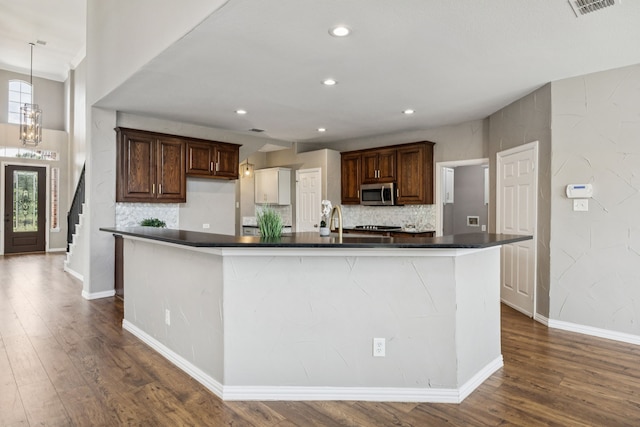 1613 Country Brook Ln, Allen, TX 75002 - kitchen with stainless steel microwave, dark countertops, dark wood-type flooring, tasteful backsplash, and recessed lighting