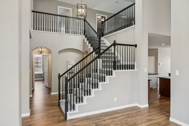 1613 Country Brook Ln, Allen, TX 75002 - stairs featuring a high ceiling, wood finished floors, arched walkways, and a chandelier