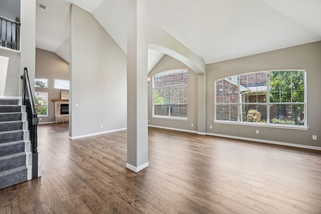 1613 Country Brook Ln, Allen, TX 75002 - unfurnished living room with lofted ceiling, dark wood-type flooring, stairs, and a glass covered fireplace