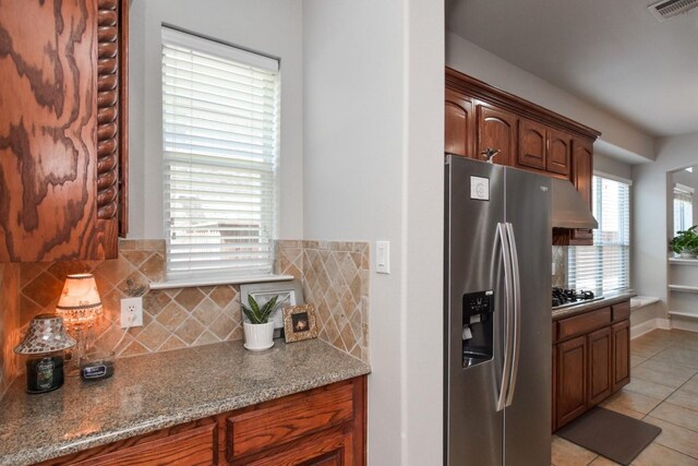 9750 Candlewood Dr, Frisco, TX 75033 - kitchen featuring stainless steel appliances, light tile patterned floors, decorative backsplash, under cabinet range hood, and stone countertops