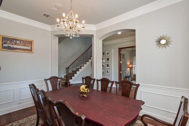 9750 Candlewood Dr, Frisco, TX 75033 - dining space with wood finished floors, arched walkways, crown molding, a chandelier, and a decorative wall