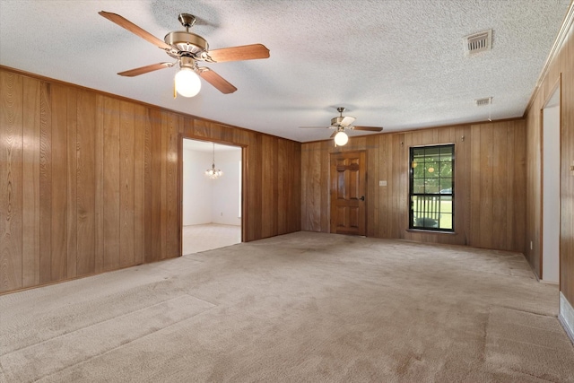 713 E Peel St, Pilot Point, TX 76258 - spare room with carpet floors, a ceiling fan, wooden walls, a chandelier, and a textured ceiling