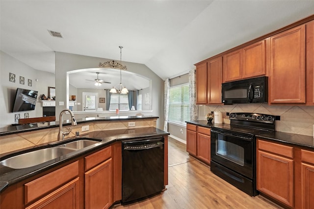 9210 Wild River Dr, Arlington, TX 76002 - kitchen with black appliances, a chandelier, light wood-style floors, lofted ceiling, and dark countertops