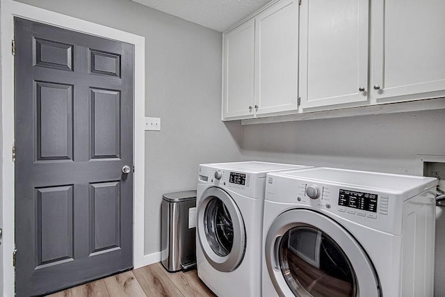 5800 Thoreau Ln, Arlington, TX 76016 - laundry room featuring cabinet space, separate washer and dryer, light wood-style floors, and a textured ceiling