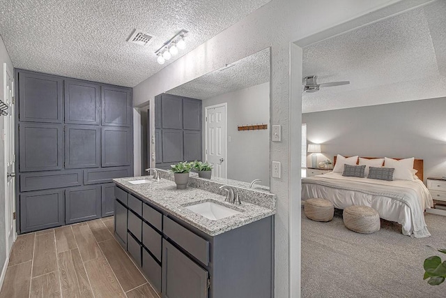 5800 Thoreau Ln, Arlington, TX 76016 - full bathroom featuring a textured ceiling, double vanity, ensuite bathroom, wood finished floors, and a ceiling fan