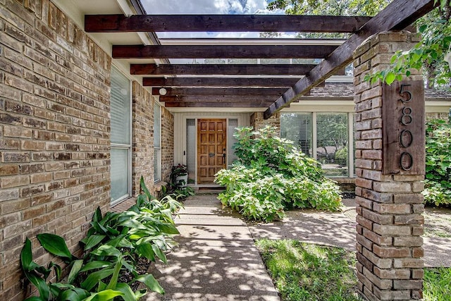 5800 Thoreau Ln, Arlington, TX 76016 - view of exterior entry with brick siding and a pergola