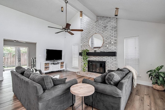 5800 Thoreau Ln, Arlington, TX 76016 - living room featuring a ceiling fan, beamed ceiling, a fireplace, wood finished floors, and high vaulted ceiling