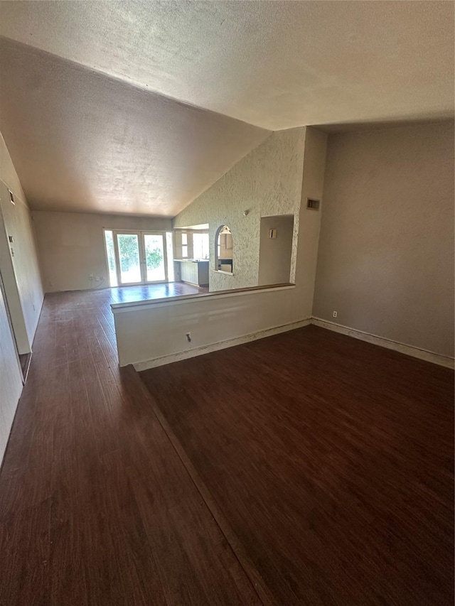 416 Meadowhill Dr, Garland, TX 75043 - unfurnished living room featuring lofted ceiling, dark wood-style floors, and a textured ceiling