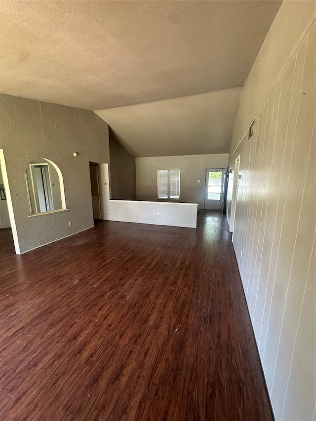 416 Meadowhill Dr, Garland, TX 75043 - unfurnished living room featuring dark wood-type flooring, lofted ceiling, and a textured ceiling