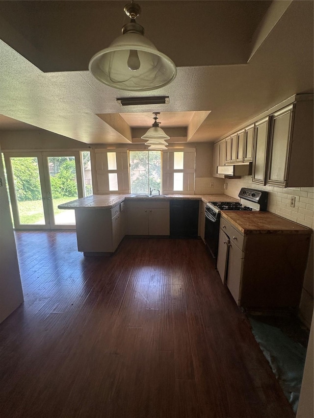 416 Meadowhill Dr, Garland, TX 75043 - kitchen with black gas range oven, range hood, a peninsula, dark wood-style flooring, and a raised ceiling