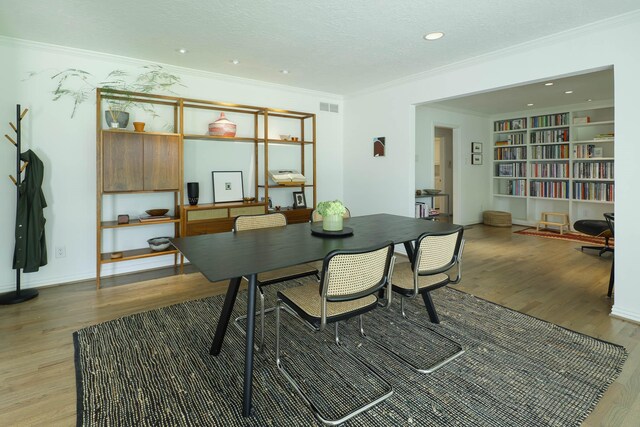 4232 Meadowdale Ln, Dallas, TX 75229 - dining space with light wood-type flooring, crown molding, a textured ceiling, recessed lighting, and built in shelves