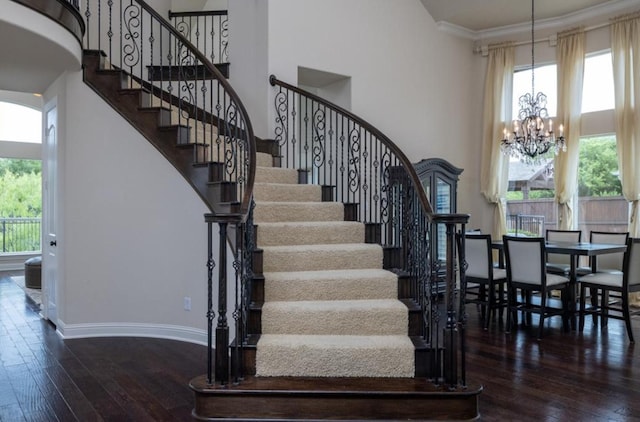 6812 S Fork Dr, North Richland Hills, TX 76182 - stairway featuring a chandelier, hardwood / wood-style floors, a towering ceiling, healthy amount of natural light, and crown molding