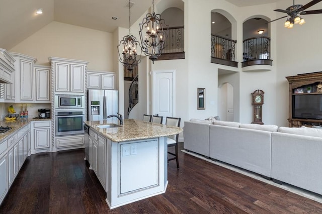 6812 S Fork Dr, North Richland Hills, TX 76182 - kitchen featuring stainless steel appliances, high vaulted ceiling, a kitchen breakfast bar, open floor plan, and dark wood-style flooring