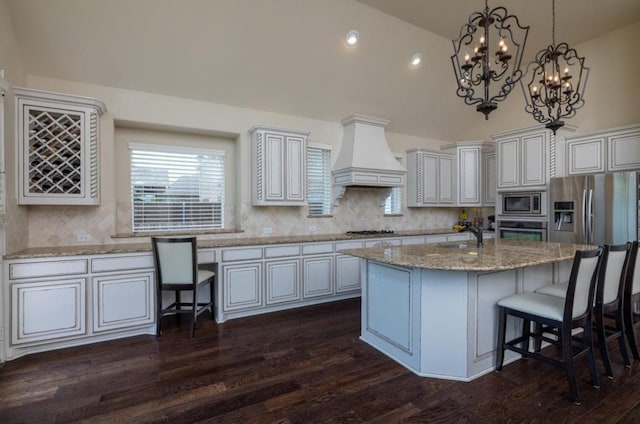 6812 S Fork Dr, North Richland Hills, TX 76182 - kitchen with premium range hood, stainless steel appliances, decorative backsplash, dark wood-style floors, and an island with sink