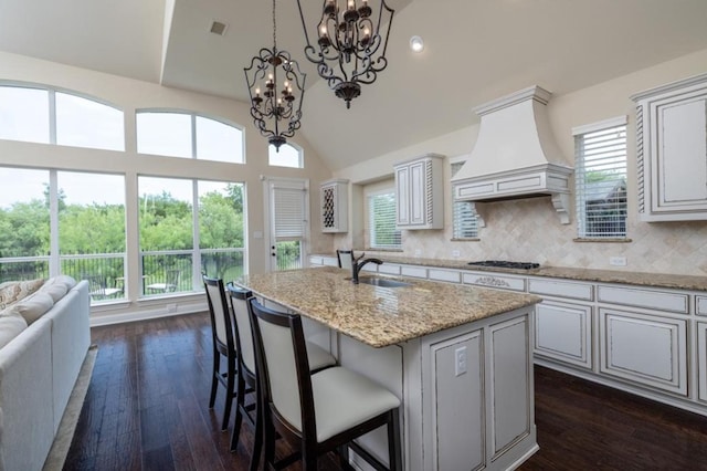 6812 S Fork Dr, North Richland Hills, TX 76182 - kitchen with premium range hood, a chandelier, dark wood finished floors, healthy amount of natural light, and lofted ceiling