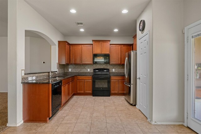 6521 La Sol Ln, Waco, TX 76712 - kitchen featuring black appliances, brown cabinets, decorative backsplash, dark stone counters, and recessed lighting