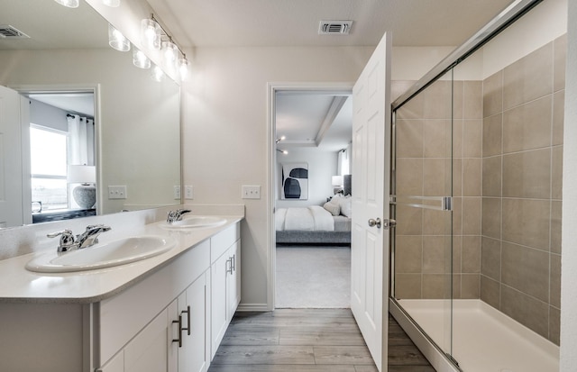 7518 Fenton Pkwy, Pilot Point, TX 76258 - ensuite bathroom featuring wood finished floors, double vanity, and a stall shower