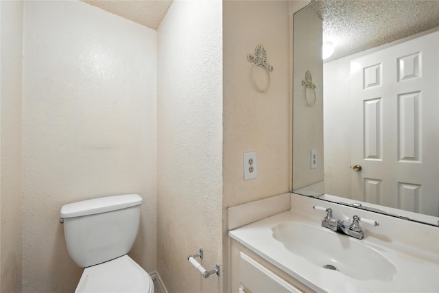 2116 S Winding Creek Dr, Grapevine, TX 76051 - half bathroom featuring vanity, a textured ceiling, and a textured wall