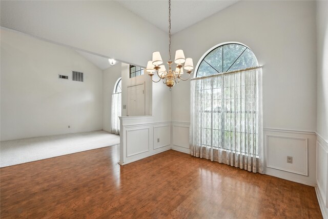 2116 S Winding Creek Dr, Grapevine, TX 76051 - empty room with a decorative wall, a chandelier, wainscoting, wood finished floors, and high vaulted ceiling