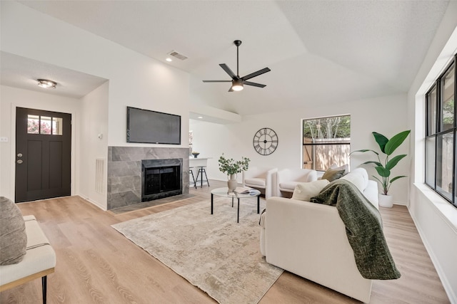 552 Kirkland Dr, Coppell, TX 75019 - living area featuring a tiled fireplace, light wood finished floors, lofted ceiling, and a ceiling fan