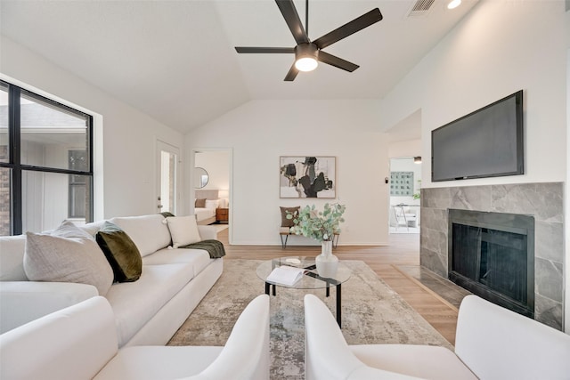 552 Kirkland Dr, Coppell, TX 75019 - living room with ceiling fan, a tiled fireplace, lofted ceiling, and light wood-style floors