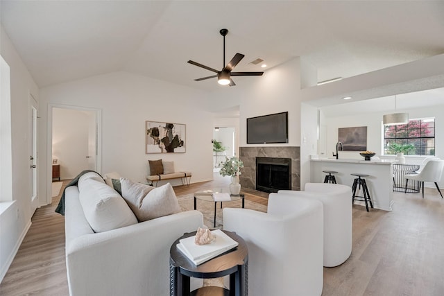 552 Kirkland Dr, Coppell, TX 75019 - living room with light wood finished floors, vaulted ceiling, a ceiling fan, a fireplace, and recessed lighting