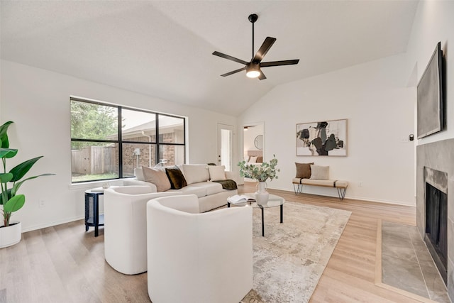 552 Kirkland Dr, Coppell, TX 75019 - living area with a tile fireplace, light wood-style floors, vaulted ceiling, and a ceiling fan