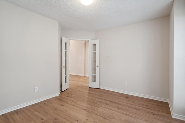 6905 Windwood Trl, Fort Worth, TX 76132 - unfurnished room featuring light wood finished floors, a textured ceiling, and french doors