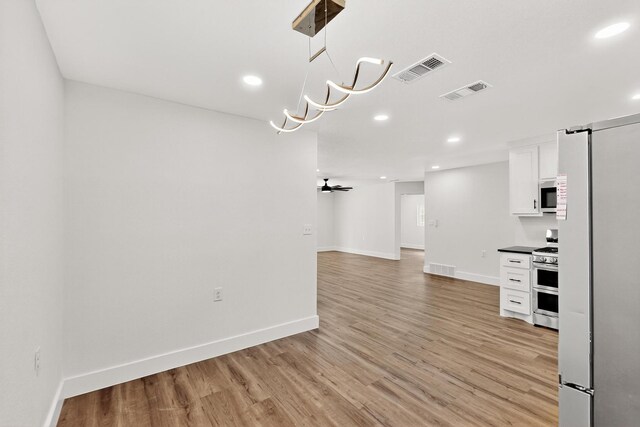 1822 Robinson St, Irving, TX 75060 - kitchen with freestanding refrigerator, white microwave, double oven range, white cabinetry, and dark countertops