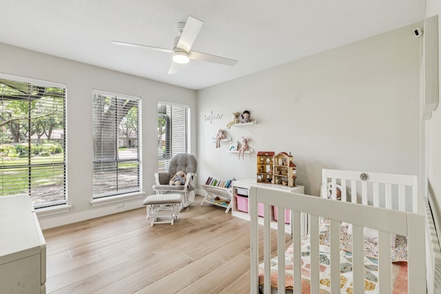 6010 Preston Creek Dr, Dallas, TX 75240 - bedroom featuring a nursery area, light wood-style floors, and a ceiling fan