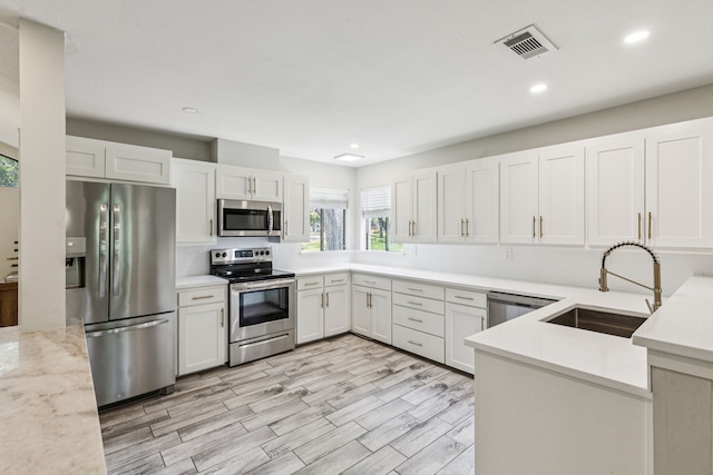 6010 Preston Creek Dr, Dallas, TX 75240 - kitchen with appliances with stainless steel finishes, recessed lighting, white cabinets, and light wood finished floors