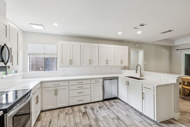 6010 Preston Creek Dr, Dallas, TX 75240 - kitchen with stainless steel appliances, a peninsula, light wood-type flooring, recessed lighting, and light countertops