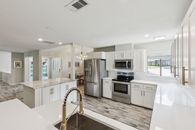 6010 Preston Creek Dr, Dallas, TX 75240 - kitchen with stainless steel appliances, a center island, light wood-type flooring, white cabinetry, and recessed lighting