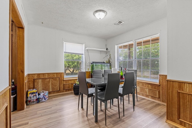 567 Celtic Rd, Howe, TX 75459 - dining room featuring wainscoting, wooden walls, plenty of natural light, a textured ceiling, and light wood-style floors
