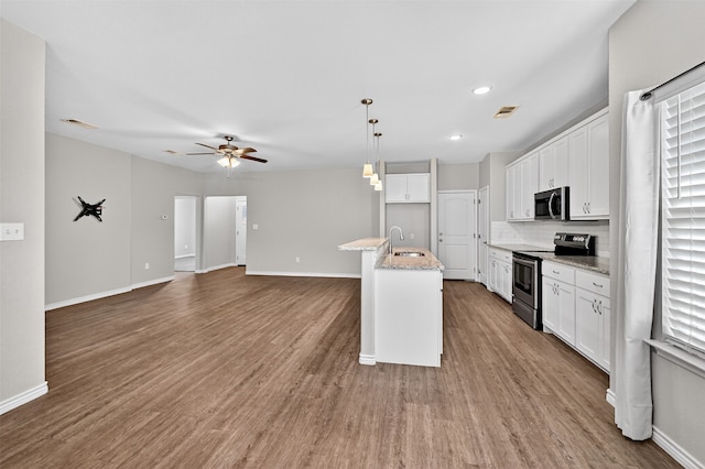 515 W Broad St, Pilot Point, TX 76258 - kitchen featuring appliances with stainless steel finishes, white cabinetry, a ceiling fan, backsplash, and light stone counters